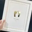 Personalised baby footprint foil print with name and date in a white frame.