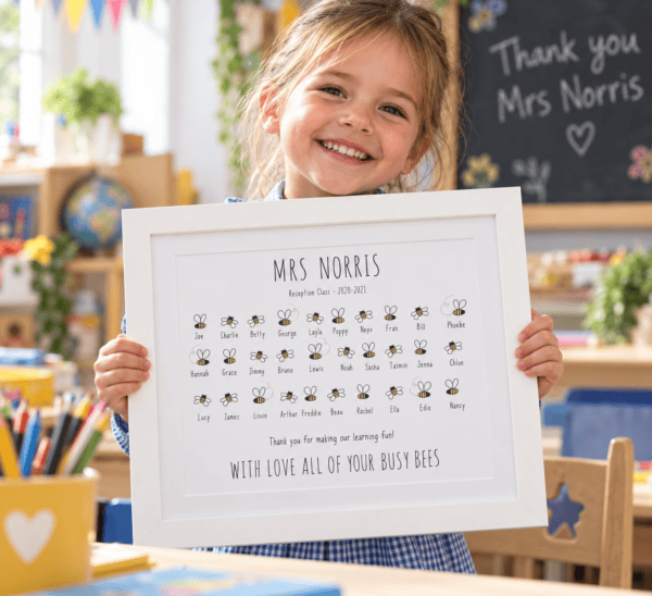 Child holding a personalised teacher thank you print with bees and names.