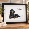 Personalised watercolor pet portrait of a dachshund named Peanut in a black frame.