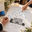 Personalised wedding fingerprint guest book with blue ink fingerprints and a venue illustration.